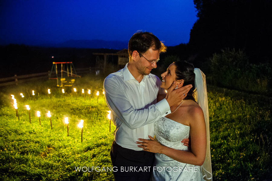 Hochzeitsfotograf Starnberg, Brautpaar vor einem Herz aus Fackeln