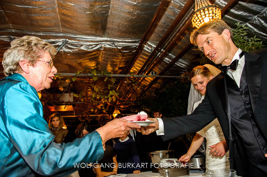 Hochzeitsfotograf München, Verteilung der Hochzeitstorte durch das Brautpaar in der Alten Gärtnerei in Taufkirchen