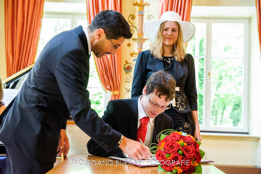 Hochzeitfoto Ismaning, Brautpaar und Standesbeamter, Unterschreiben bei der Trauung