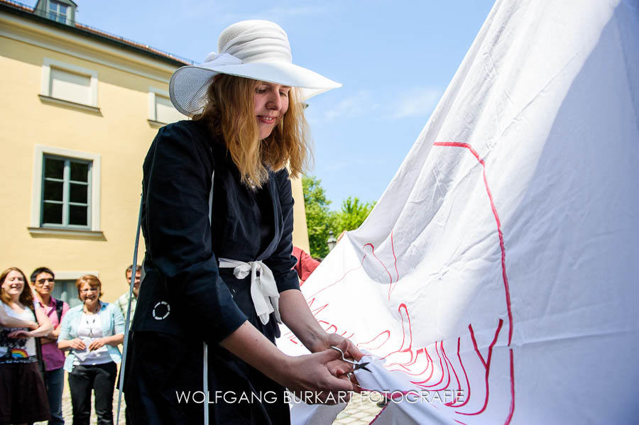 Hochzeit Fotograf Ismaning, Braut schneidet Herz aus Bettlaken ausschneiden