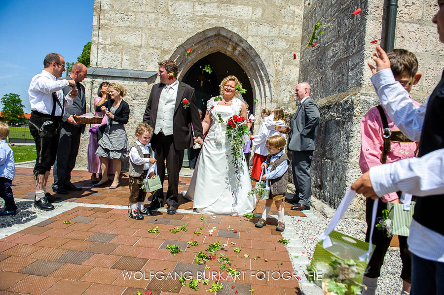 Hochzeitsfotografie Tegernsee, Brautpaar mit Blumenkindern beim Auszug